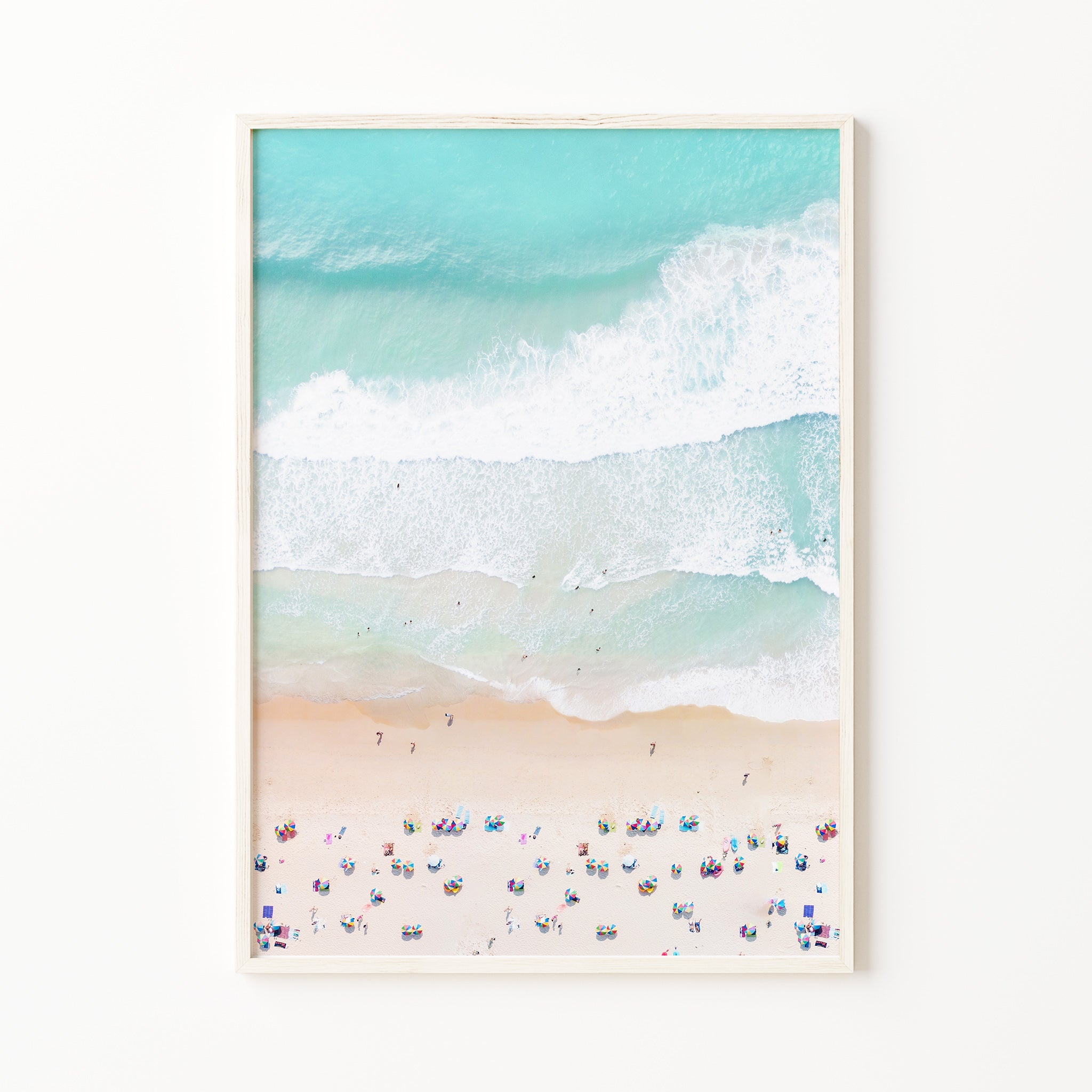Aerial beach print with turquoise ocean waves and white foam, sandy shore with people and colorful umbrellas, pastel coastal wall art large