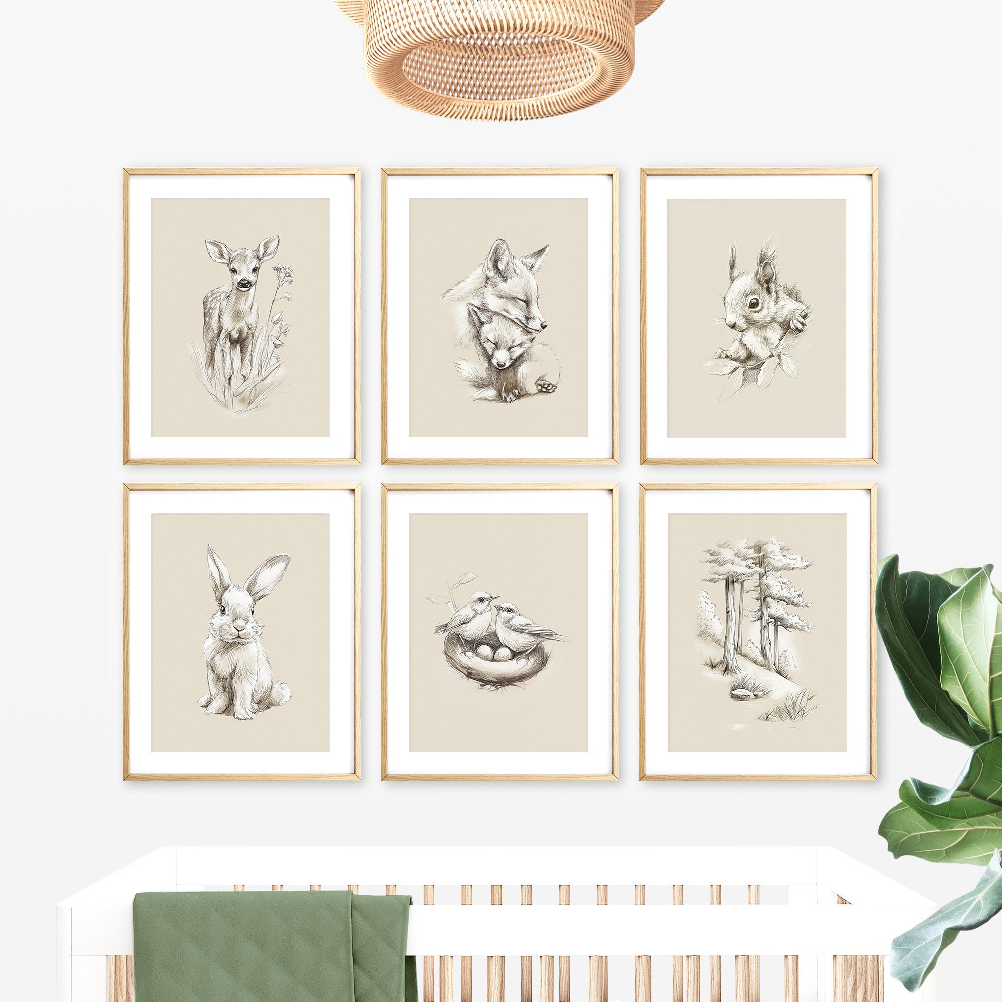 Neutral woodland animal nursery wall art prints set including deer, fox, rabbit, squirrel, birds nest and pine forest illustrations in natural wood frames above a white crib. Forest nursery decor, woodland baby room wall art, Scandinavian nursery prints, gender neutral nursery artwork, woodland animal gallery set, large printable wall art, digital download